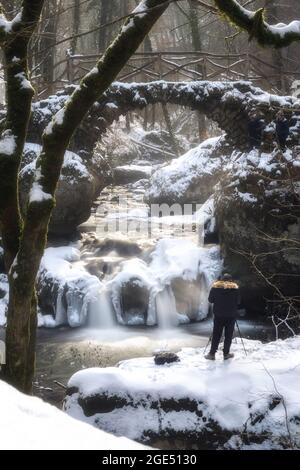 Schiessentuempel avec un photographe dans la forêt de Mullerthal en hiver au Luxembourg Banque D'Images