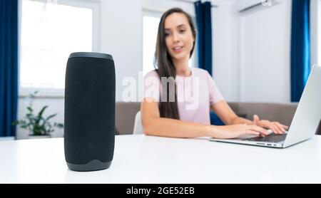 Femme utilisant une enceinte intelligente, un système domestique intelligent, un assistant moderne Banque D'Images