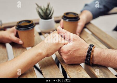 Gros plan d'un couple senior romantique tenant la main dans un café extérieur pendant la date, espace de copie Banque D'Images