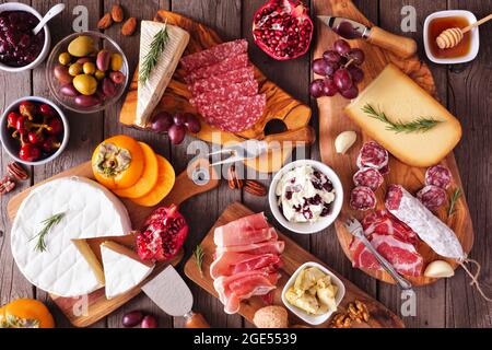 Tableaux de charcuterie composés de fromages, viandes et hors-d'œuvre variés. Scène de table au-dessus de la vue sur un fond de bois rustique. Banque D'Images