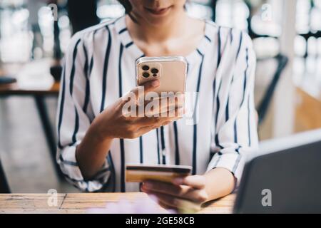 Femme profiter avec l'application d'achat en ligne sur le téléphone cellulaire et utiliser l'appareil photo pour scanner la carte de crédit pour remplir le numéro de paiement Banque D'Images