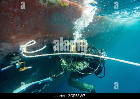 Navy Diver 2nd Class Brandon Barreto, affecté à l'unité mobile de sauvetage de plongée (MDSU) 2, effectue des opérations de réparation de dégâts de combat sous-marins (BDR) sur le destroyer de classe Arleigh Burke USS Gonzales (DDG-66) pendant un exercice à grande échelle (LSE 2021). Le LSE 2021 démontre la capacité de la Marine à employer des forces précises, létales et écrasantes à l’échelle mondiale sur trois commandes de composantes navales, cinq flottes numérotées et 17 fuseaux horaires. Le LSE 2021 associe les capacités d'entraînement en direct et synthétique pour créer un environnement d'entraînement intense et robuste. Il permettra de relier les formations haute fidélité et les opérations réelles au bui Banque D'Images