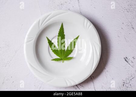 Feuille de cannabis - la marijuana laisse la plante sur la plaque blanche, cannabis alimentaire nature herbe concept Banque D'Images