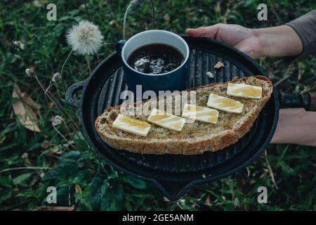 Machine maison crumb ouvert croustillant artisan pain de levain avec beurre et miel, tasse de café, dans l'arrière-cour, fond naturel Banque D'Images