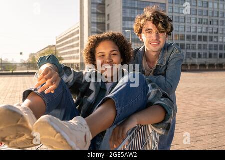 Deux adolescents gaies s'amusant dans un environnement urbain contre l'architecture moderne Banque D'Images