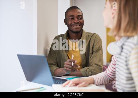 Portrait d'un jeune étudiant afro-américain étudiant avec des amis à l'école et souriant heureusement, l'espace de copie Banque D'Images