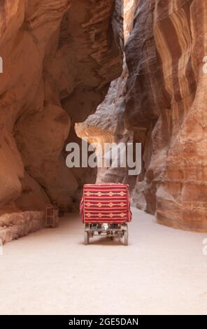 Chariot dans le Siq, Petra, Jordanie, Moyen-Orient. Le Siq est une division naturelle dans la roche formant un passage à travers la ville cachée de Petra. Banque D'Images