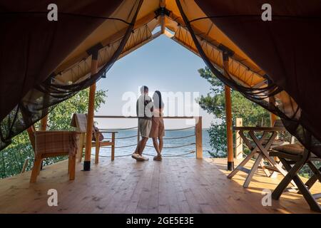 Vue arrière d'un couple amoreux se tenant à proximité l'un de l'autre et regardant l'océan bleu tout en appréciant les vacances d'été Banque D'Images