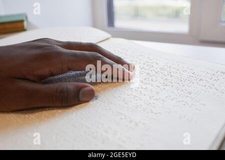 Gros plan de la main afro-américaine lecture livre en braille pour aveugle, espace de copie Banque D'Images