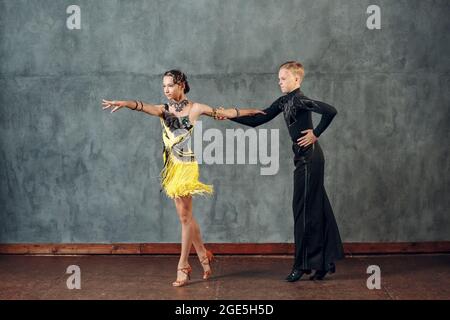 Salle de bal danse samba. Jeune couple en costumes jaune et noir dansant Banque D'Images