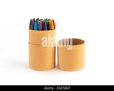 Crayons cireux colorés dans une boîte en carton écologique isolée sur fond blanc. Bâtonnets pastel colorés non toxiques de cire pigmentée dans un gobelet en papier pour l'écriture artistique Banque D'Images