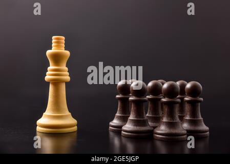 Maîtrise du pouvoir et de la foule et des classes parmi les hommes avec le concept avec des pièces d'échecs sur table noire et fond Banque D'Images