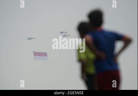 Jakarta, Indonésie. 17 août 2021. Des hélicoptères volent avec le drapeau national de l'Indonésie lors de la célébration du 76e jour de l'indépendance de l'Indonésie à Jakarta, Indonésie, le 17 août 2021. Credit: Zulkarnain/Xinhua/Alamy Live News Banque D'Images