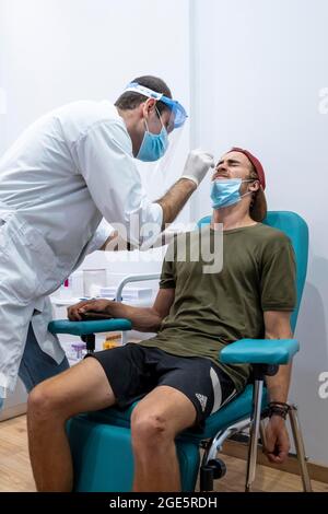 Médecin en vêtements de protection fait un test d'antigène sur un jeune homme, test de coronavirus, Covid-19, Kalymnos, Grèce Banque D'Images