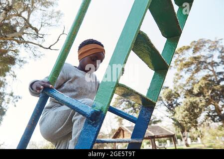 Belle fille africaine noire sur le toboggan dans le parc Banque D'Images
