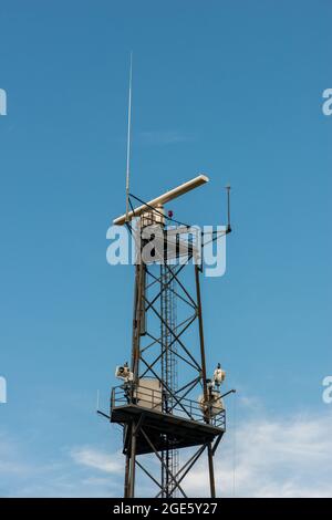Station radar de surveillance côtière militaire contre ciel bleu. Banque D'Images
