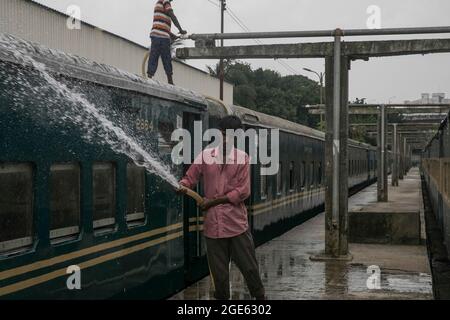 DHAKA, BANGLADESH - AOÛT 9 : un employé de chemin de fer nettoie un train à la gare de Kamalapur. Les services de transport public sur terre, sur rail et sur les voies navigables doivent reprendre leurs activités après la fin du confinement de Covid-19. Dimanche, la Division du Cabinet a publié une circulaire confirmant que le confinement strict national a été effectué à Dhaka, au Bangladesh, le 9 août 2021. Crédit : Groupe EYEPIX/accès photo Banque D'Images