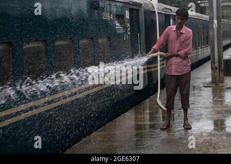 DHAKA, BANGLADESH - AOÛT 9 : un employé de chemin de fer nettoie un train à la gare de Kamalapur. Les services de transport public sur terre, sur rail et sur les voies navigables doivent reprendre leurs activités après la fin du confinement de Covid-19. Dimanche, la Division du Cabinet a publié une circulaire confirmant que le confinement strict national a été effectué à Dhaka, au Bangladesh, le 9 août 2021. Crédit : Groupe EYEPIX/accès photo Banque D'Images