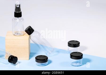 Bouteilles de voyage transparentes en plastique pour cosmétiques sur podium en bois : savon, gel, lotion, crème, shampooing, maquillage et liquides. Concept de voyage moderne. Copier Banque D'Images