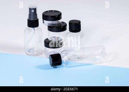 Groupe de bouteilles de voyage en plastique transparent pour cosmétiques : savon, gel, lotion, crème, shampooing, Maquillage et liquides sur fond bleu clair. Moderne Banque D'Images