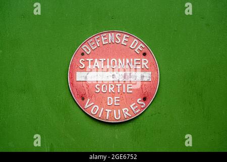 Pas d'affiche de stationnement en français. Parking interdit, sortie de voiture. Cercle rouge sur fond vert, style vintage. Banque D'Images