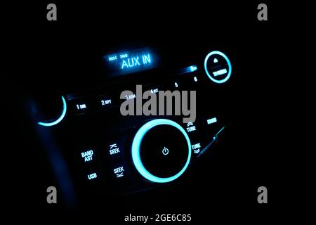 Autoradio stéréo avec éclairage au néon la nuit. Tableau de bord avec équipement audio dans la cabine de la nouvelle voiture moderne Banque D'Images