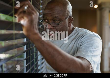 Un homme afro-américain attentif regarde la fenêtre Banque D'Images