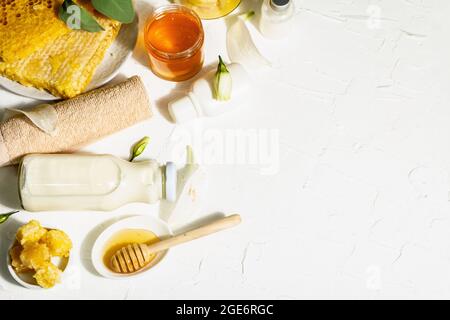 Concept spa avec miel et lait. Cosmétiques naturels, ingrédients biologiques. Lumière dure, ombre foncée. Fond blanc, vue de dessus Banque D'Images