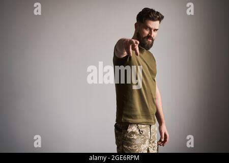 Militaire barbu portant un uniforme et montrant le geste « Je vous regarde » Banque D'Images