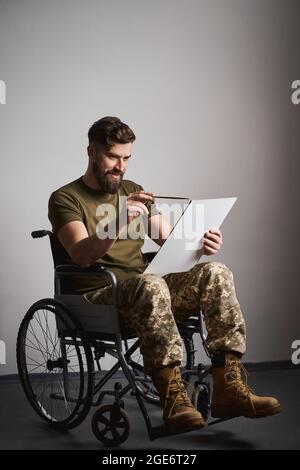 Soldat handicapé assis dans un fauteuil roulant et peint sur une toile Banque D'Images