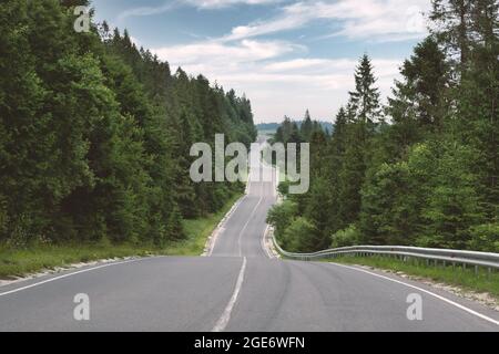 Route de montagne sinueuse dans la forêt verte d'été. Ukraine, montagnes carpathes. Photographie de paysage Banque D'Images
