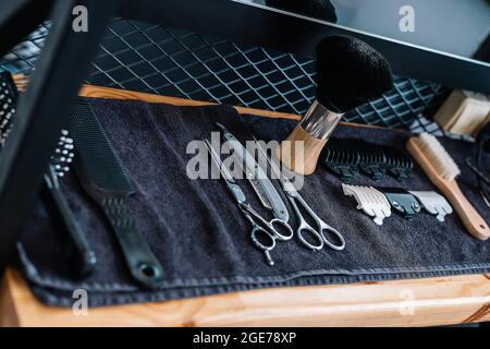 Outils et équipements professionnels de coiffure. Brosse de rasage, rasoir, ciseaux, peignes sur la table, sur une serviette noire. Salon de coiffure. Professionnel pour hommes Banque D'Images