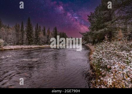 Image combinée de paysage fluvial nocturne près de Mörkret en Suède avec des forêts de conifères le long des rives et de petits rapides dans l'eau courante Banque D'Images