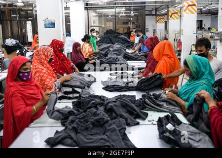 Dhaka, Bangladesh. 17 août 2021. Les travailleurs du vêtement prêt-à-porter (RMG) portant des masques au cours de leur travail, par mesure de précaution contre la propagation du coronavirus, à l'usine de vêtements civil Engineering Limited à Dhaka. Crédit : SOPA Images Limited/Alamy Live News Banque D'Images