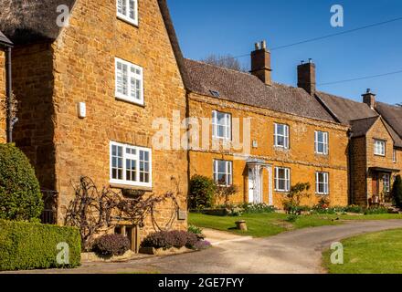 Royaume-Uni, Angleterre, Oxfordshire, Wroxton, main Street, Jolies cottages en pierre historiques autour du village vert Banque D'Images