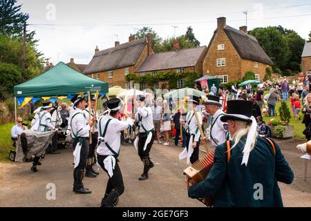 Royaume-Uni, Angleterre, Oxfordshire, Wroxton, fête annuelle de l'église en cours, Morris Dancers avec bâtons sur main Street, au bord du village vert Banque D'Images