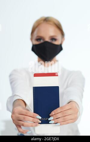 Passeport et billet d'avion dans les mains de femme sur fond flou Banque D'Images