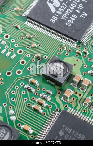Gros plan d'une inductance de puissance blindée sur un circuit imprimé à montage en surface / SM (le blindage coupe les interférences magnétiques) + d'autres composants SM. Marques non connues. Banque D'Images
