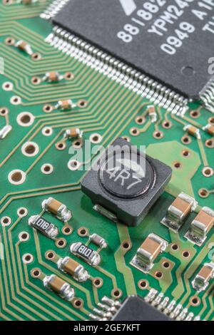 Gros plan d'une inductance de puissance blindée sur un circuit imprimé à montage en surface / SM (le blindage coupe les interférences magnétiques) + d'autres composants SM. Marques non connues. Banque D'Images