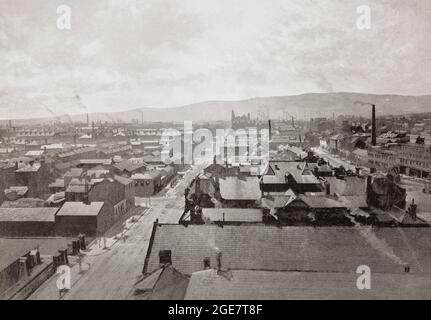 La première des trois vues panoramiques de la fin du XIXe siècle sur Belfast, la capitale et la plus grande ville d'Irlande du Nord, se tenant sur les rives de la rivière Lagan sur la côte est. Belfast a été un port important jouant un rôle important dans la révolution industrielle en Irlande, lui gagnant le surnom de "Linenopolis" comme un centre majeur de la production de lin irlandais, de la transformation du tabac et de la fabrication de corde. La construction navale était également une industrie clé; le chantier naval Harland et Wolff, qui a construit le RMS Titanic, était le plus grand chantier naval du monde. Chichester Street est la route principale Banque D'Images