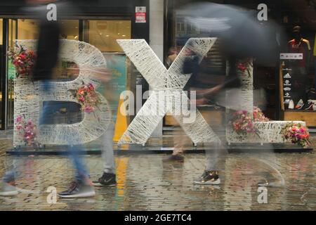 Bruxelles, Belgique. 17 août 2021. Les gens marchent devant une installation de fleurs dans le centre de Bruxelles, Belgique, le 17 août 2021. Un événement floral « Bruxelles à Bloom » a eu lieu du 15 août au 5 septembre de cette année dans les rues autour de la Grand-place de Bruxelles, alors que le tapis de fleurs a été déplacé en août 2022. Credit: Zheng Huansong/Xinhua/Alay Live News Banque D'Images