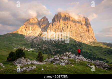 Vue aérienne d'une personne qui admire le groupe Sassolungo pendant un lever de soleil d'été. Col Sella, Dolomiti, quartier de Bolzano, Trentin-Haut-Adige, Italie, Europe. Banque D'Images