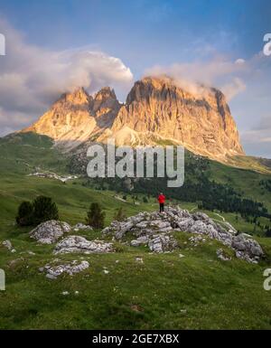 Vue aérienne d'une personne qui admire le groupe Sassolungo pendant un lever de soleil d'été. Col Sella, Dolomiti, quartier de Bolzano, Trentin-Haut-Adige, Italie, Europe. Banque D'Images