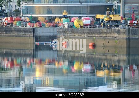 Belle vue matinale de divers équipements marins dans le port de Dun Laoghaire (West Pier) avec reflet coloré de bouées dans l'eau. Mise au point douce Banque D'Images