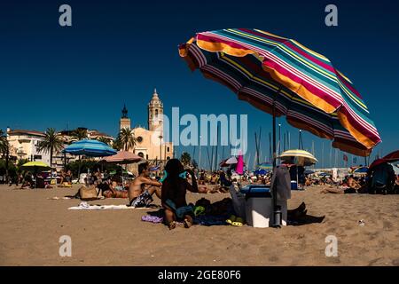 Sitges, Espagne. 17 août 2021. Les touristes et les résidents apprécient une matinée ensoleillée à la plage de Sitges avec des températures modérées après la première vague de chaleur de l'Espagne de 2021 records de marquage depuis 1941 terminé dans la péninsule ibérique. Credit: Matthias Oesterle/Alamy Live News Banque D'Images