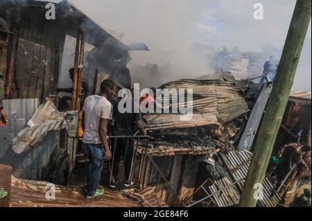 Nairobi, Kenya. 17 août 2021. Les résidents ont vu des toits qui essayaient de déclencher un incendie à Bombolulu, Kibera.les résidents se sont joints aux mains pour aider à faire un incendie qui s'est produit aujourd'hui après-midi à partir de fils électriques emmêlés alimentant différentes maisons en électricité. Le feu a rasé douze maisons et propriétés laissant la plupart des résidents bloqués. (Photo de Donwilson Odhiambo/SOPA Images/Sipa USA) crédit: SIPA USA/Alay Live News Banque D'Images