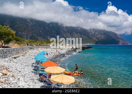 AGIA ROUMELLI, CRÈTE - 20 JUILLET 2021 : touristes se détendant sur la plage rocheuse du village d'Agia Roumelli près de la sortie de la gorge de Samaria sur l'is Banque D'Images