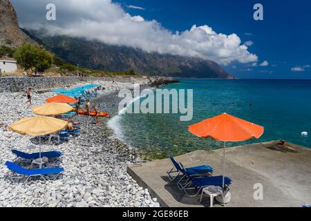 AGIA ROUMELLI, CRÈTE - 20 JUILLET 2021 : touristes se détendant sur la plage rocheuse du village d'Agia Roumelli près de la sortie de la gorge de Samaria sur l'is Banque D'Images