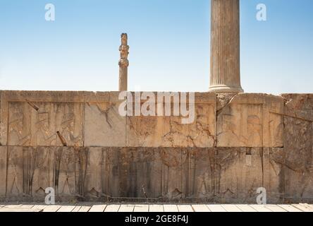 Ruines d'Apadana et du palais de Tachara derrière l'escalier avec des sculptures de bas relief à Persepolis site du patrimoine mondial de l'UNESCO contre ciel bleu nuageux à Shira Banque D'Images