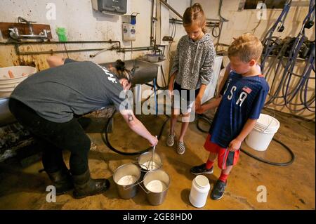 Shavertown, États-Unis. 17 août 2021. Un conseiller enseigne aux campeurs comment préparer du lait pour les veaux. Chaque été, les enfants qui ont subi un traumatisme ou une perte sont acceptés au camp de deuil agricole. Les enfants apprennent les corvées de base de la ferme mais ont aussi la chance d'interagir avec les animaux et les conseillers. Le camp comprend également des thérapies et des leçons pour aider les enfants à faire face aux pertes qu'ils ont subies. Le camp se trouve sur une ferme éducative appelée « les terres à Hillside ». Crédit : SOPA Images Limited/Alamy Live News Banque D'Images